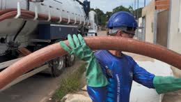 Operador com luvas manuseando o mangote